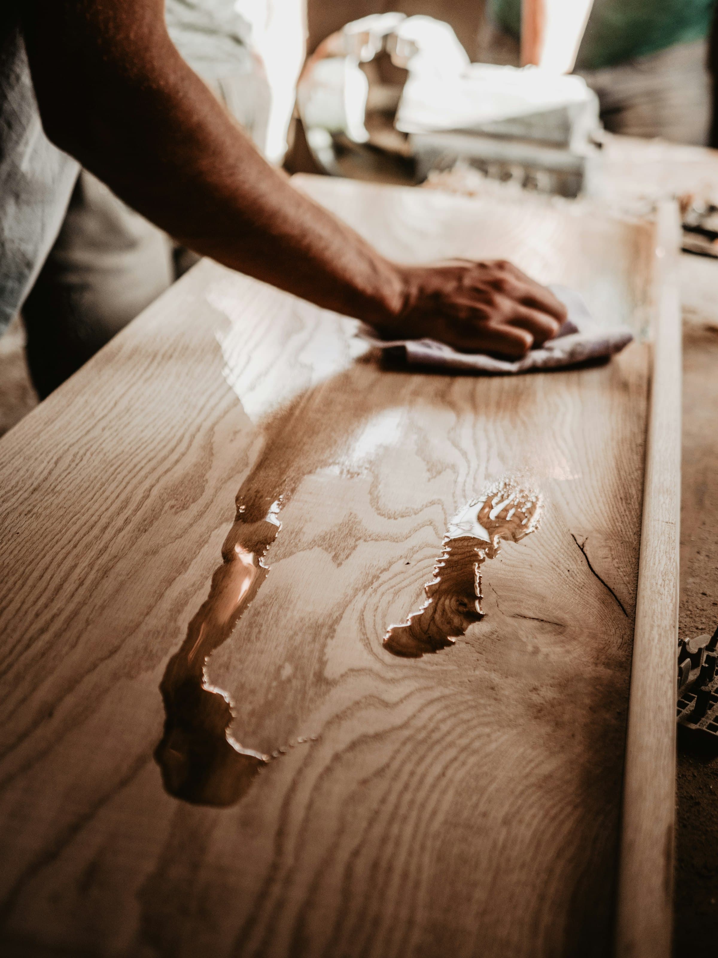 Mano lustrando una tabla de madera maciza